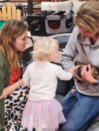 Emma holding a kitten, as a child and woman pet it