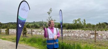 Bridget standing at the parkrun start line with a clipboard in hand and hi-vis vest on.