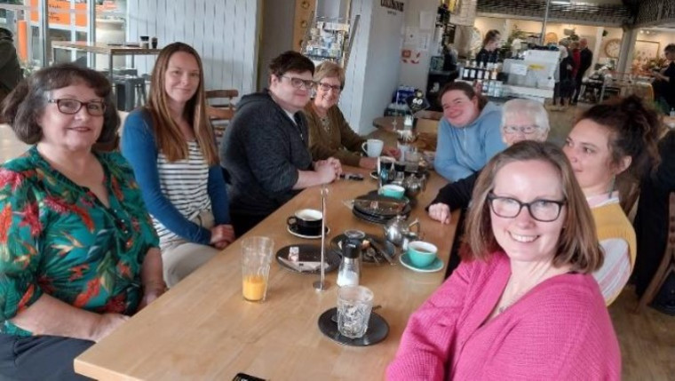 A group of people around a table at a cafe