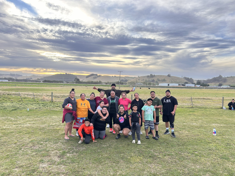 A group of people on a field with a sunset behind them