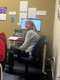 Sallyann sat in a computer chair smiling at the camera.