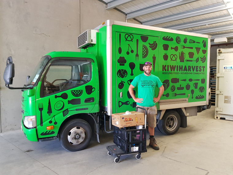 Jasper standing in front of a green Kiwi harvest truck