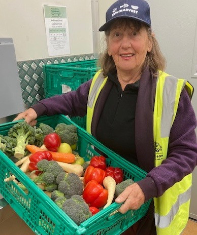 volunteer Phillipa Jones, KiwiHarvest volunteer with a basket of fresh fruit and vegetables